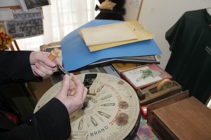 Kay Teer, daughter of longtime mayor Yvonne Jenkins, who also worked to preserve the town's history, holds sewing needle bobbins - part of the many items now in the Meadows Building, which soon will be sold. (Photo by Dawn Cobb)